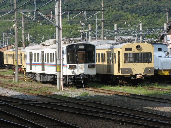 彦根駅構内に留置されている220形（左）。右は部品取り用として放置されている旧西武401系。