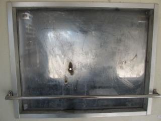 タバコを押し付けられたと思しき跡が残る乗務員室仕切り窓。