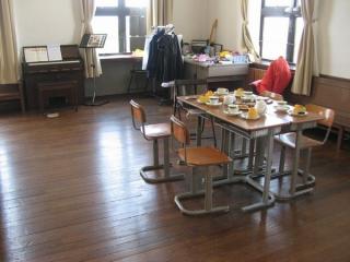 校舎3階の「音楽室」こと会議室。作中での描画にあわせて机や楽器などが並べられている。机の上のケーキはロウでできた見本品。