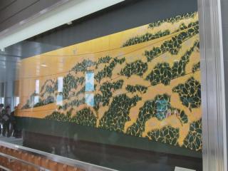 改札口前にある室瀬和美作の漆絵「木精」がある。